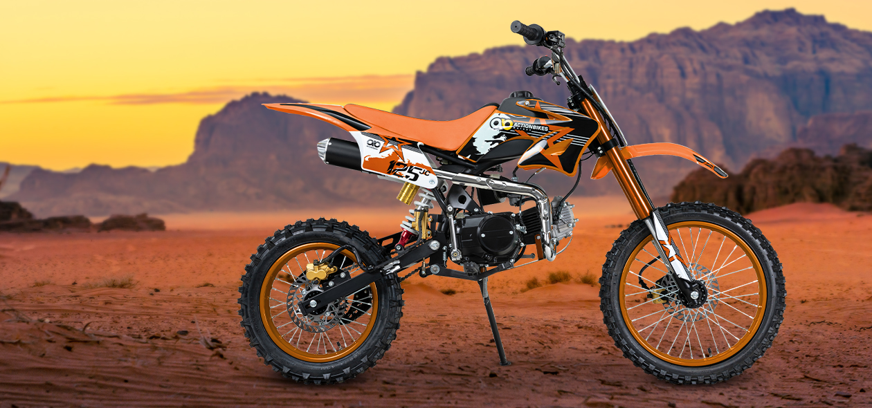 Orangefarbenes Jugend-Crossbike von der Seite in bergiger Prärie