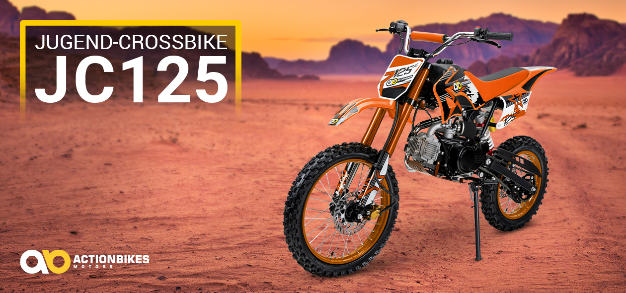Jugend-Crossbike JC125 in Orange, abgestellt auf rötlichem Sand