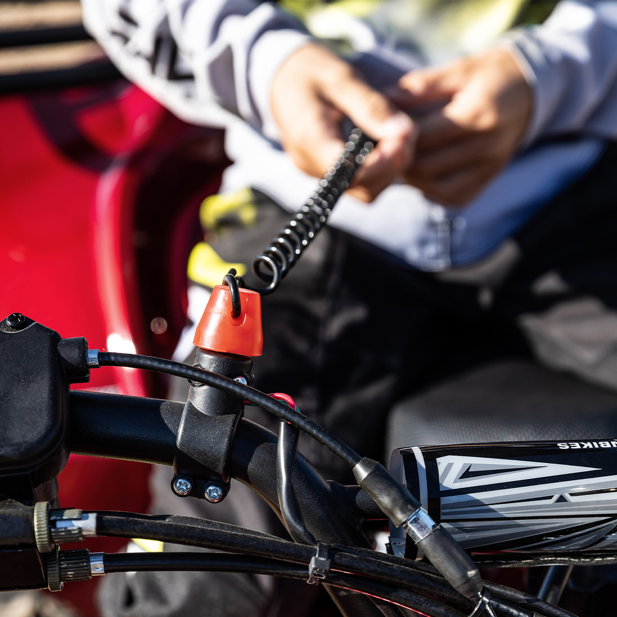 Junge befestigt die Not-Aus-Leine des Benzin-Jugend-Quad an seiner Kleidung