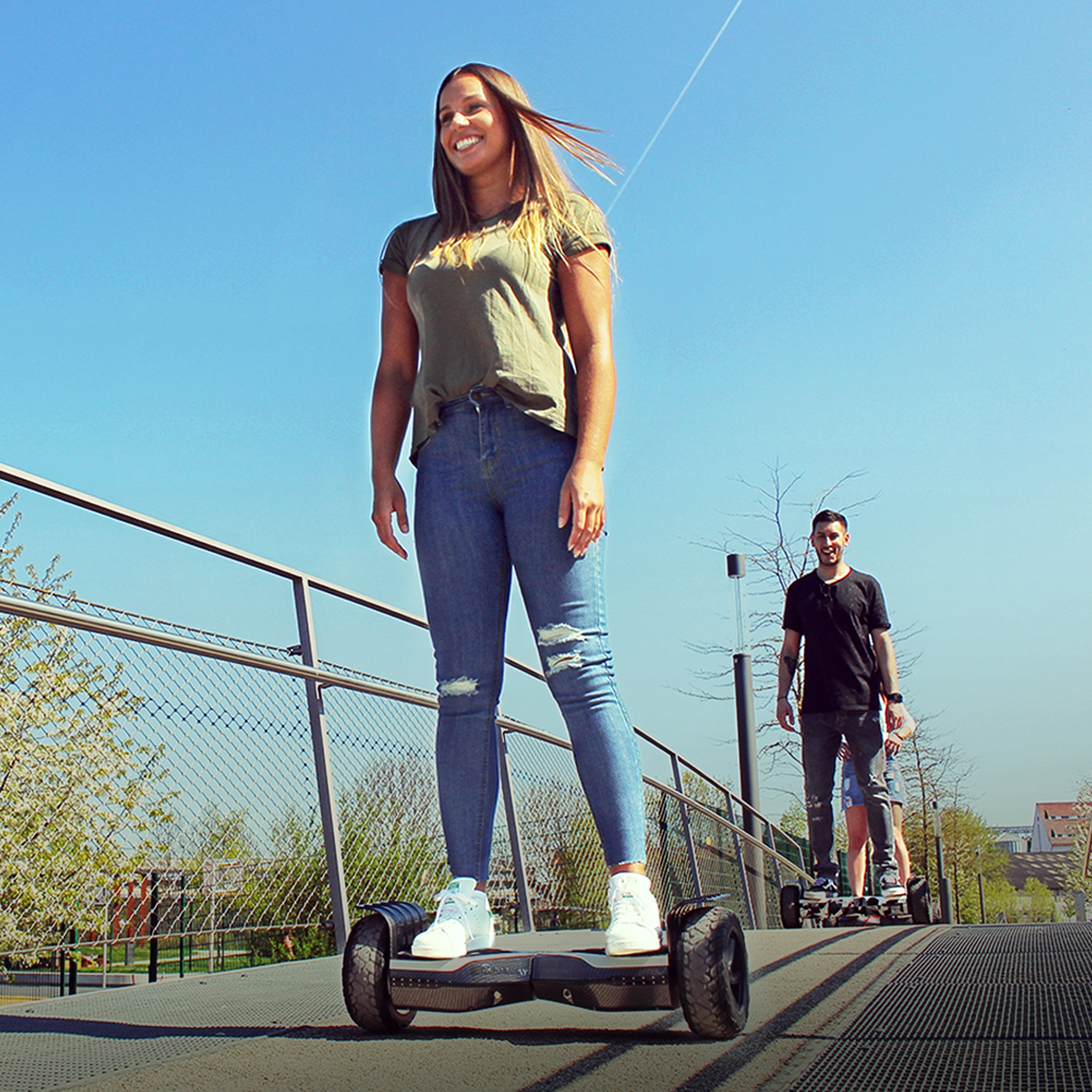 Mit 700-Watt-Motoren auf bis zu 15 km/h Erwachsenengruppe fährt mit den Robway X2 Hoverboards über eine Brücke