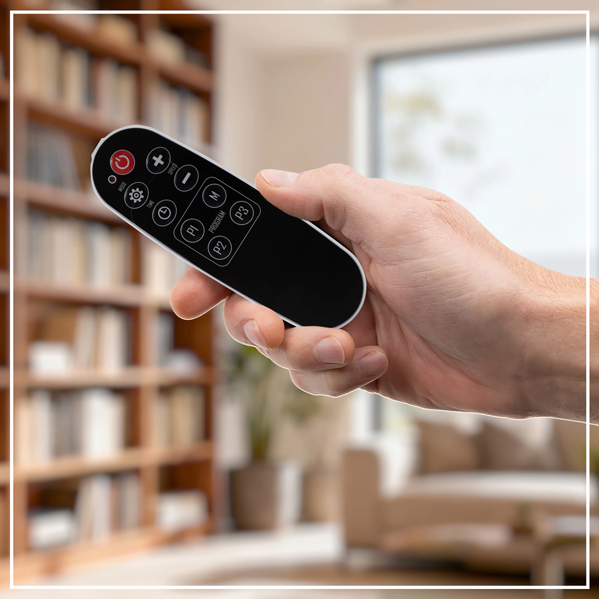 Frau dr&uuml;ckt auf einen Knopf auf der Fernbedienung der Vibrationsplatte