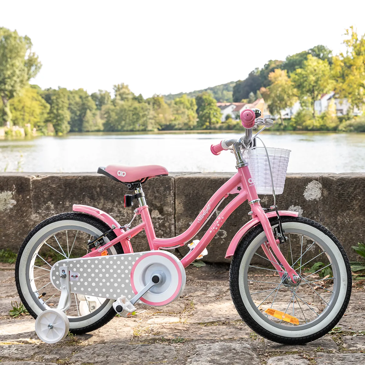 Ein Traum in Pastellrosa Rosa 16-Zoll-Kinderfahrrad Starlight mit Stützrädern auf steinigem Boden