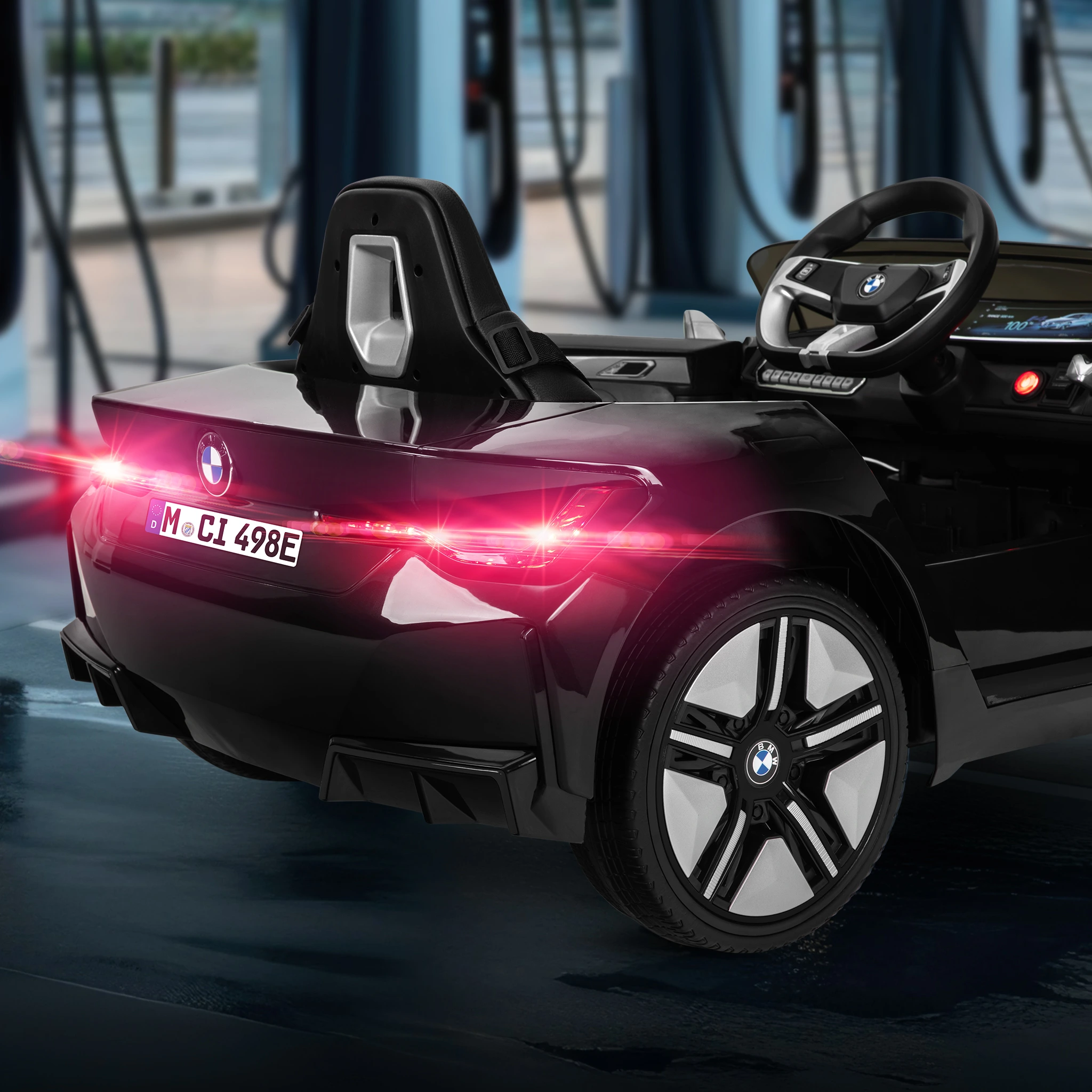 BMW-Kinderauto Design Kinder-Elektroauto BMW i4 Premium von hinten mit leuchtenden Rückleuchten