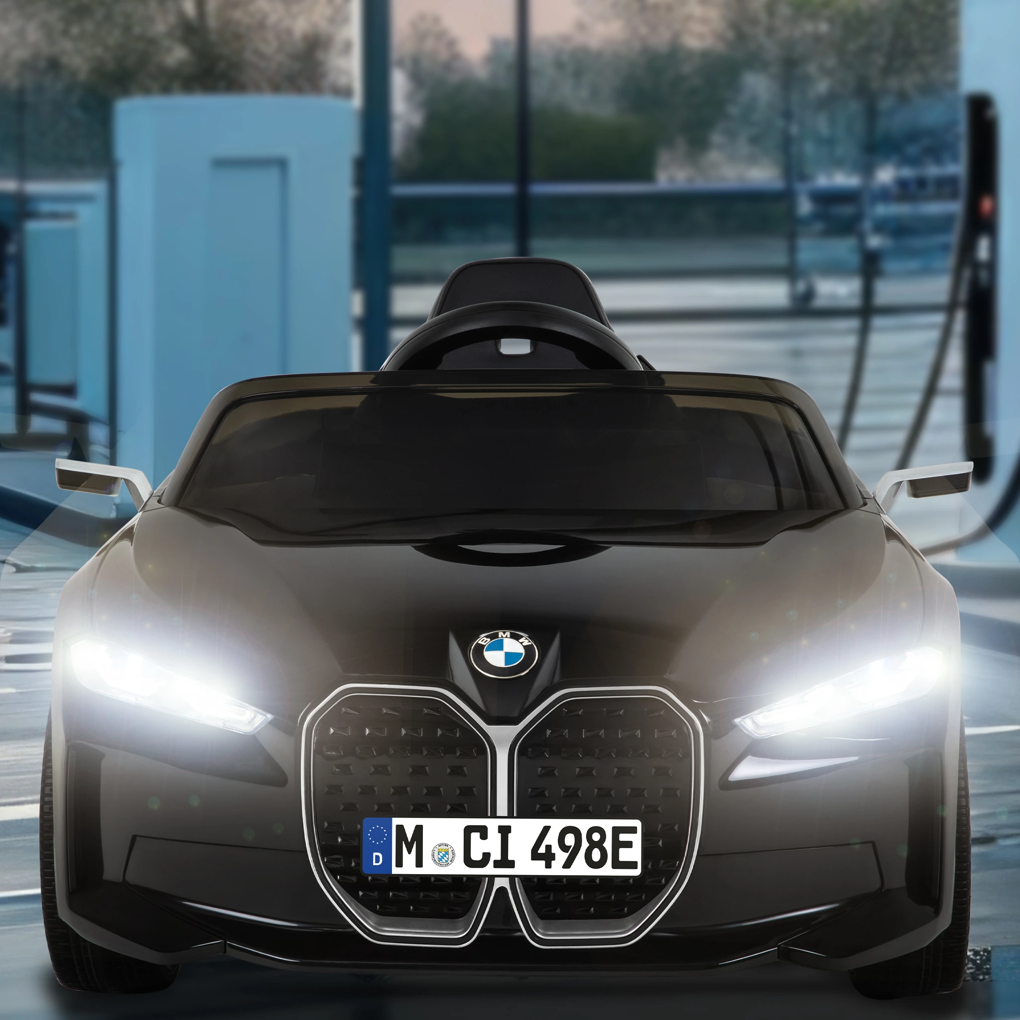 LED-Scheinwerfer des BMW i4 Premium Kinder-Elektroauto BMW i4 Premium von vorne mit leuchtenden LED-Scheinwerfern