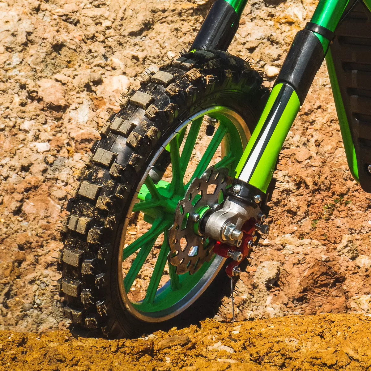 Vergrößerter Reifen des grünen Kindermotorrads mit dickem Profil