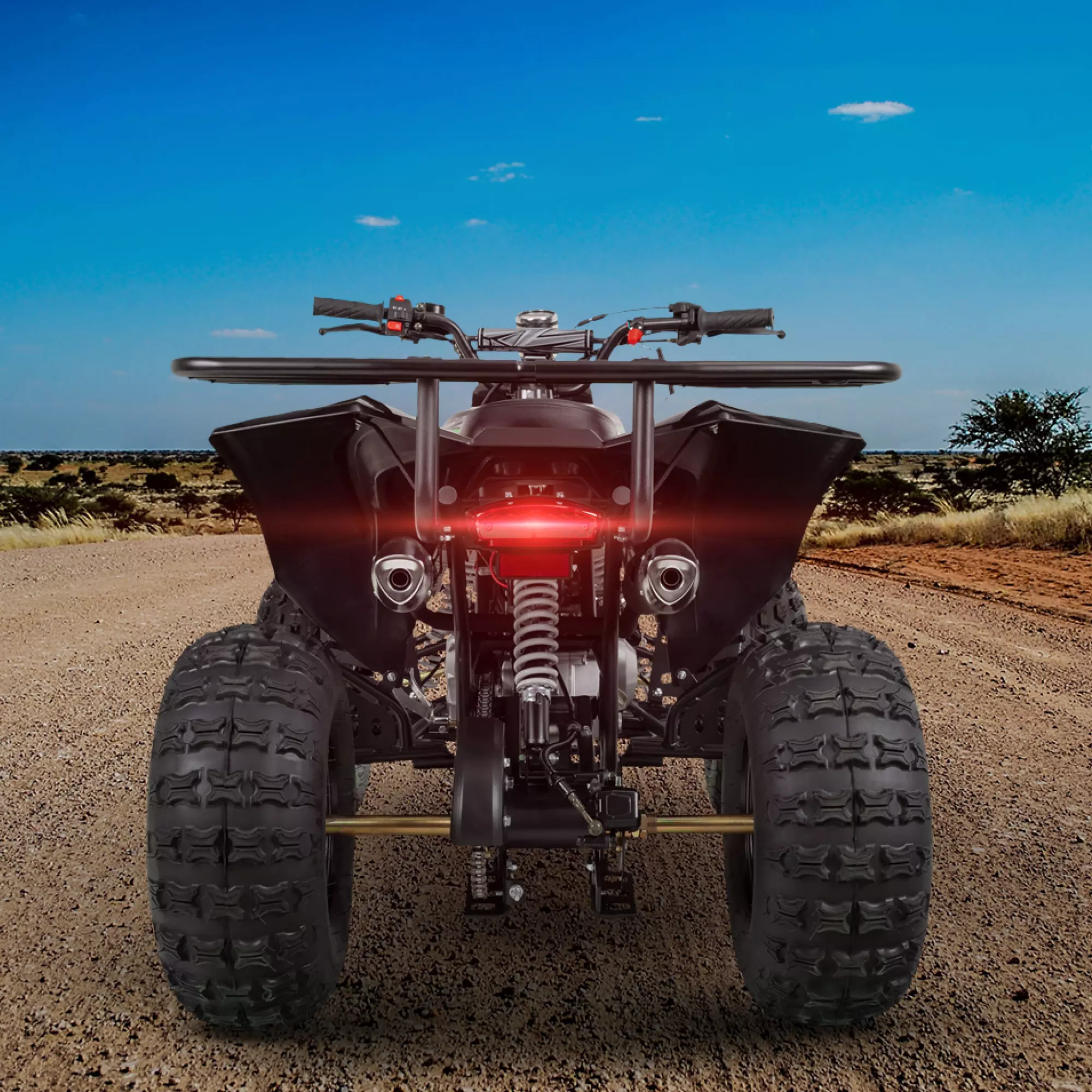 Kinderquad mit Vorwärts- und Rückwärtsgang Kinderquad von hinten mit rot leuchtendem Rückstrahler auf sandiger Straße