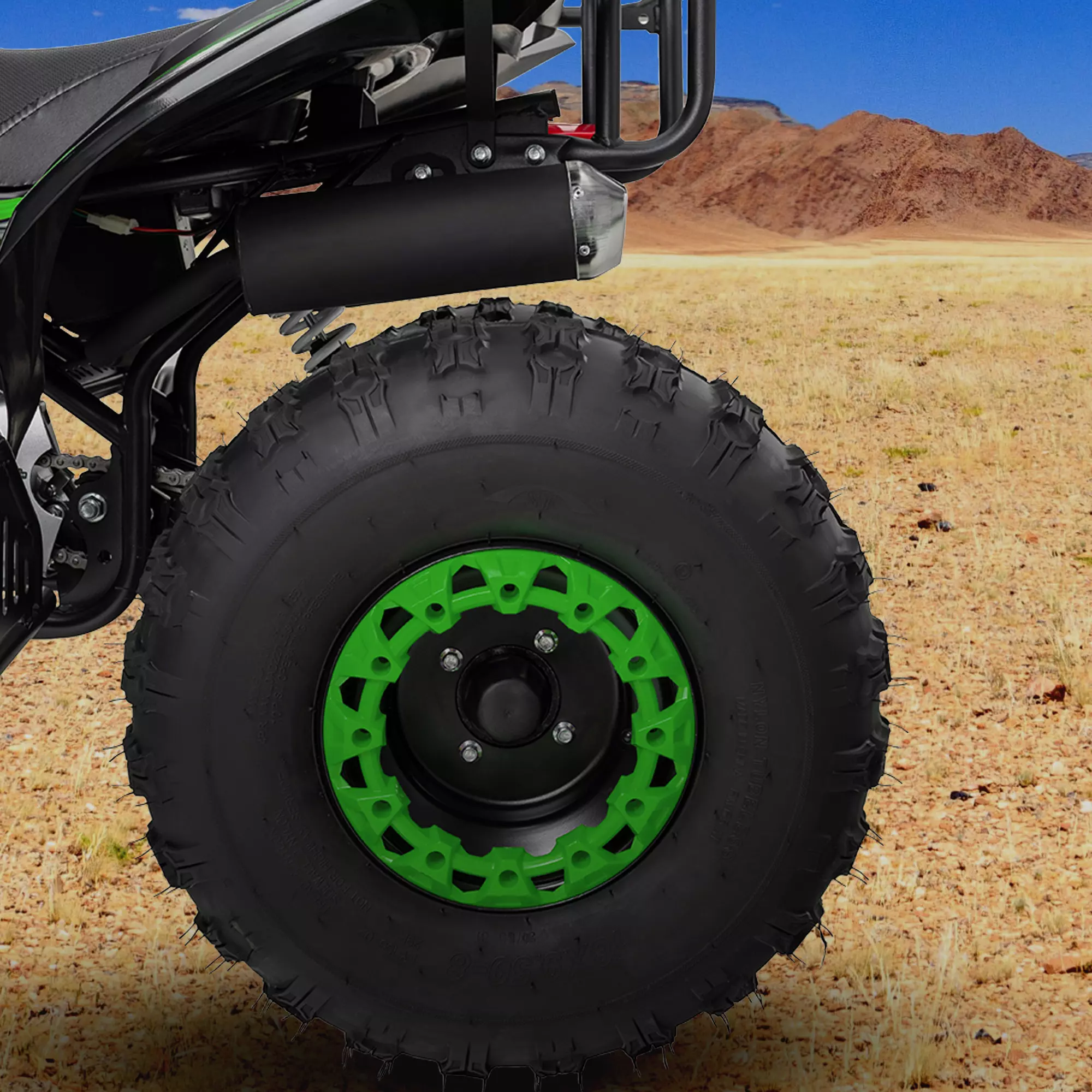 Kinderquad mit 8-Zoll-Reifen und Stoßdämpfern Vergrößerte schwarz-grüne Reifen des Kinderquads auf sandigem Boden in Wüstenlandschaft