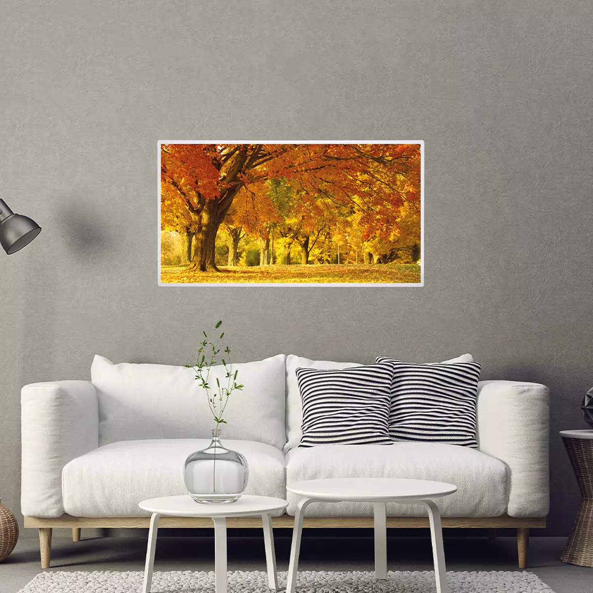 Infrarotheizung mit Herbst-Motiv an Wohnzimmerwand über weißem Sofa