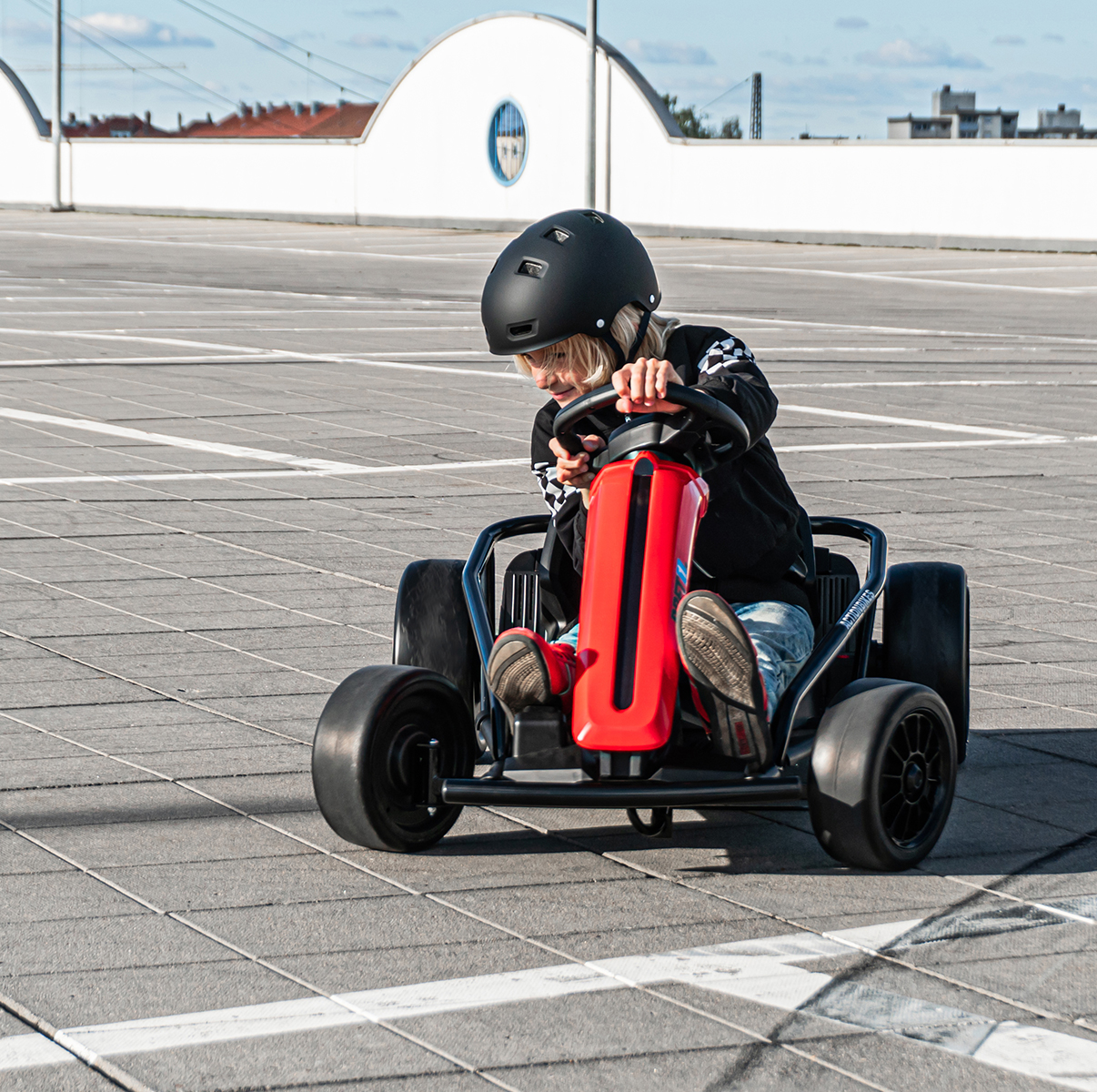 Junge steuert das rot-schwarze Drift-Kart SX1968 über den Asphalt