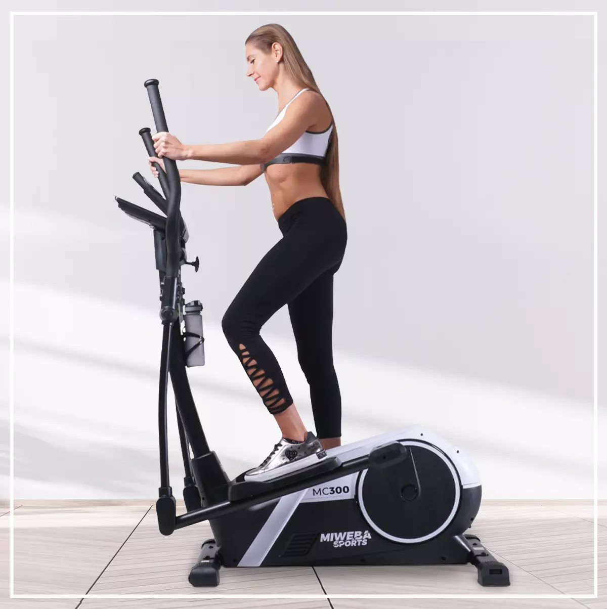 Miweba Sports Crosstrainer MC300 von der Seite, Frau trainiert lächelnd darauf