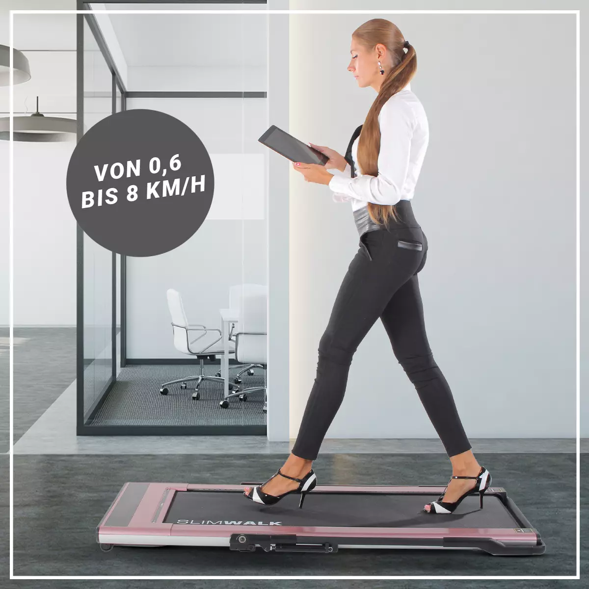 Einstellbare Geschwindigkeit von 0,6 bis 8 km/h Frau trainiert mit Tablet in den Händen auf dem Laufband im Büro