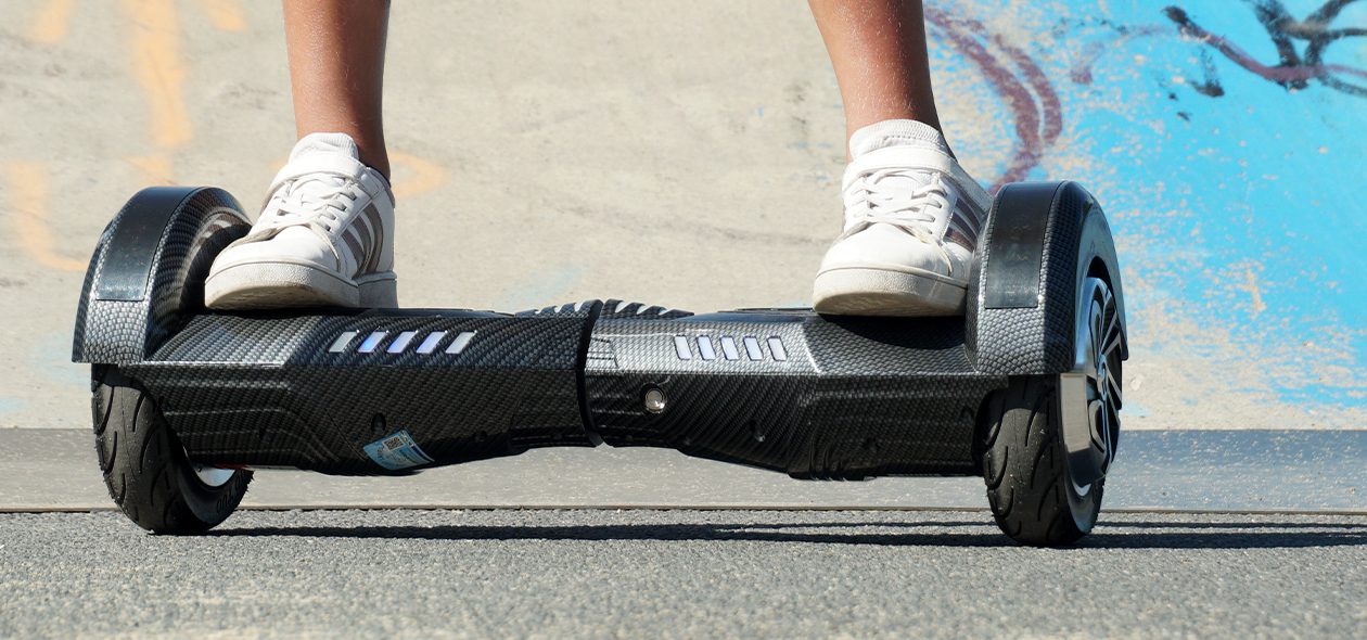 Füße eines Kindes steuern das Hoverboard von Robway über den Asphalt