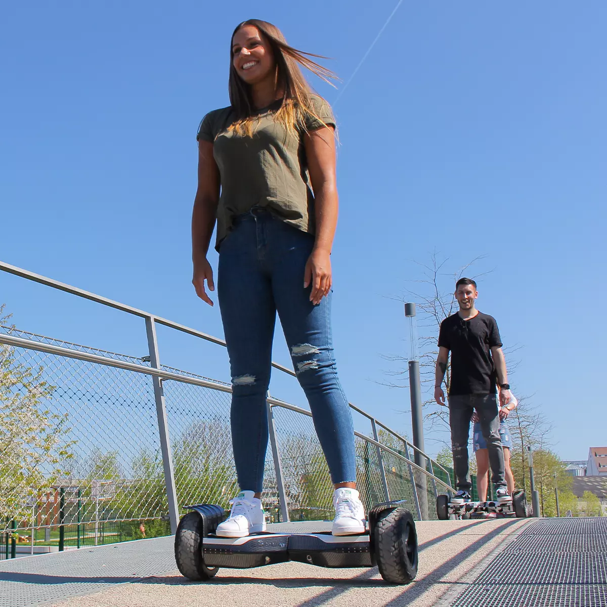 Erwachsenengruppe fährt mit den Robway X2 Hoverboards über eine Brücke