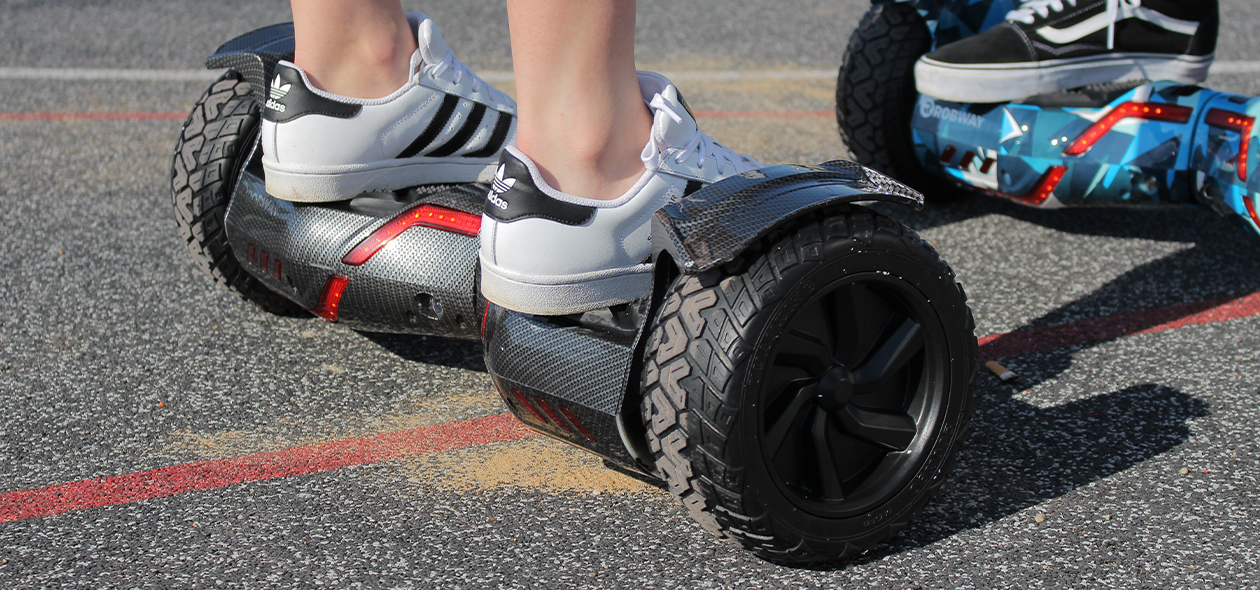 Füße einer Frau in weißen Sneakern auf dem Hoverboard von Robway